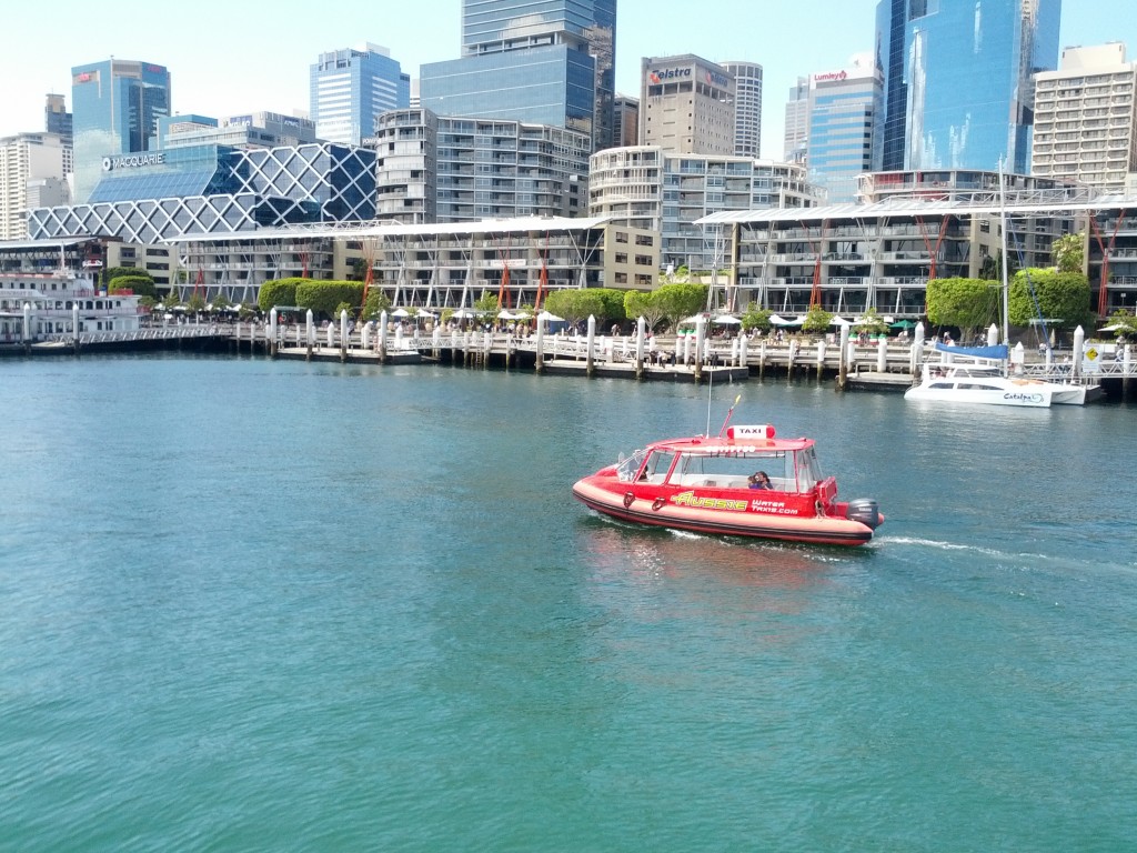 A water ferry cruises through Darling Harbour, near the maritime museum.